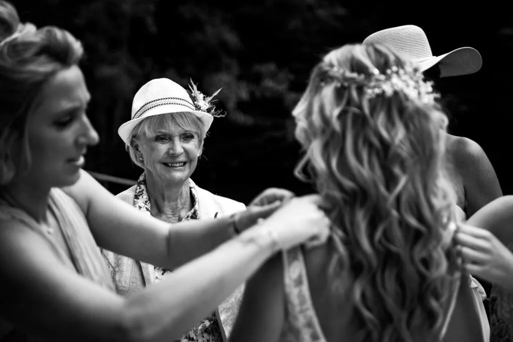 En noir et blanc, le photographe saisit avec pudeur le regard tendre et ému de la mère observant la mariée pendant les derniers instants de préparation, révélant un lien intime et une émotion silencieuse captée avec sensibilité.