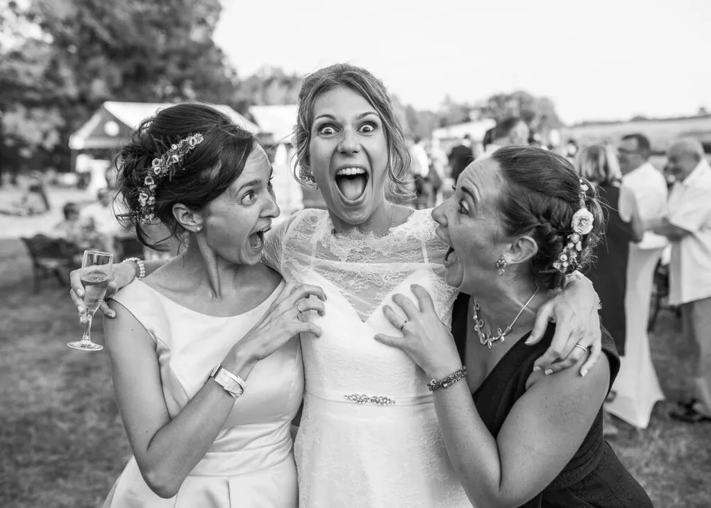 La mariée éclate de rire entourée de ses témoins lors du vin d’honneur, dans un moment de joie spontanée.