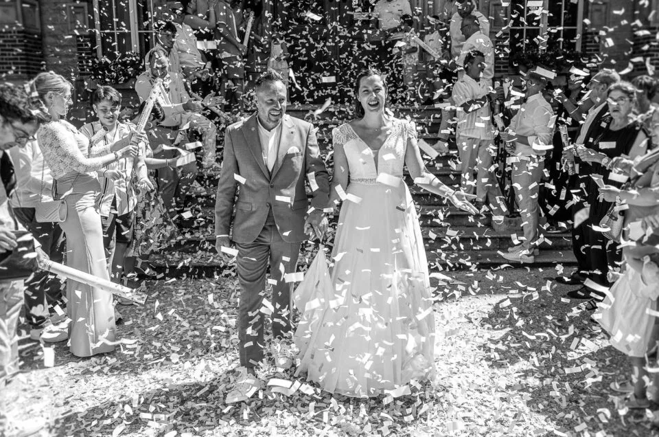 Les mariés avancent sous une pluie de confettis à la sortie de la cérémonie.