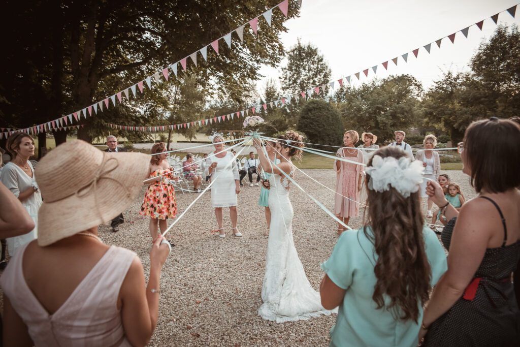 Jeu du ruban autour de la mariée lors du vin d’honneur au Domaine de Vauluisant près de Troyes, ambiance festive d’un mariage en extérieur.