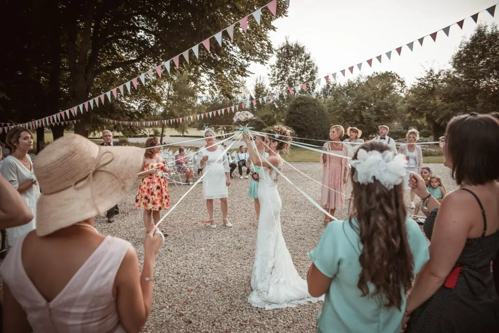 Jeu du ruban autour de la mariée lors du vin d’honneur au Domaine de Vauluisant près de Troyes, ambiance festive d’un mariage en extérieur.