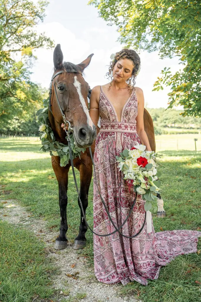La mariée avec son cheval dans un chemin du château de Vaux
