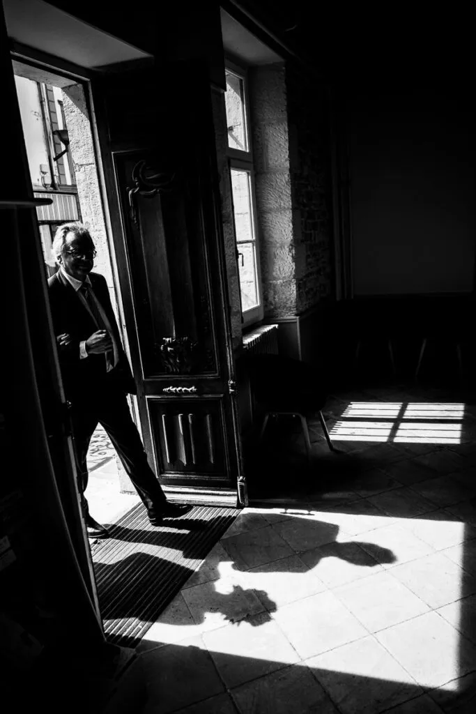 photo en noir et blanc très contrastée avec les ombres portées de la mariée et son papa qui arrivent à la mairie